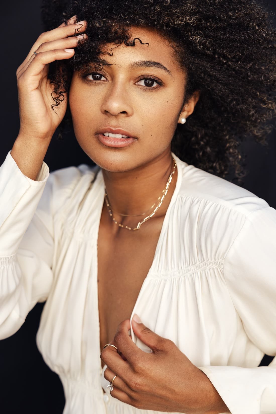 Jada Newton-Etkins, founder of Sonder Permanent Jewelry Co., wearing layered gold chains